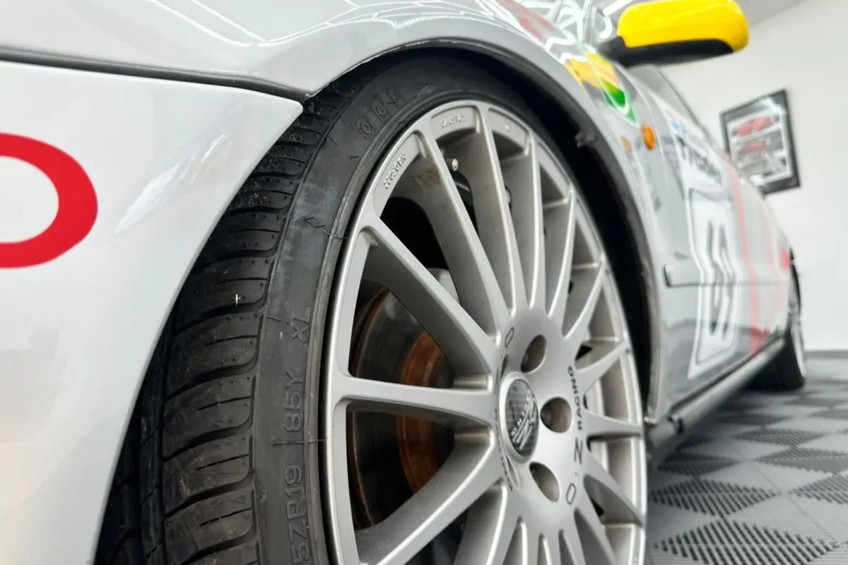 Detail des Audi A4 B5 STW: silberne OZ-Racing-Vielspeichenfelge mit 19-Zoll-Reifen, dahinter gelber Außenspiegel