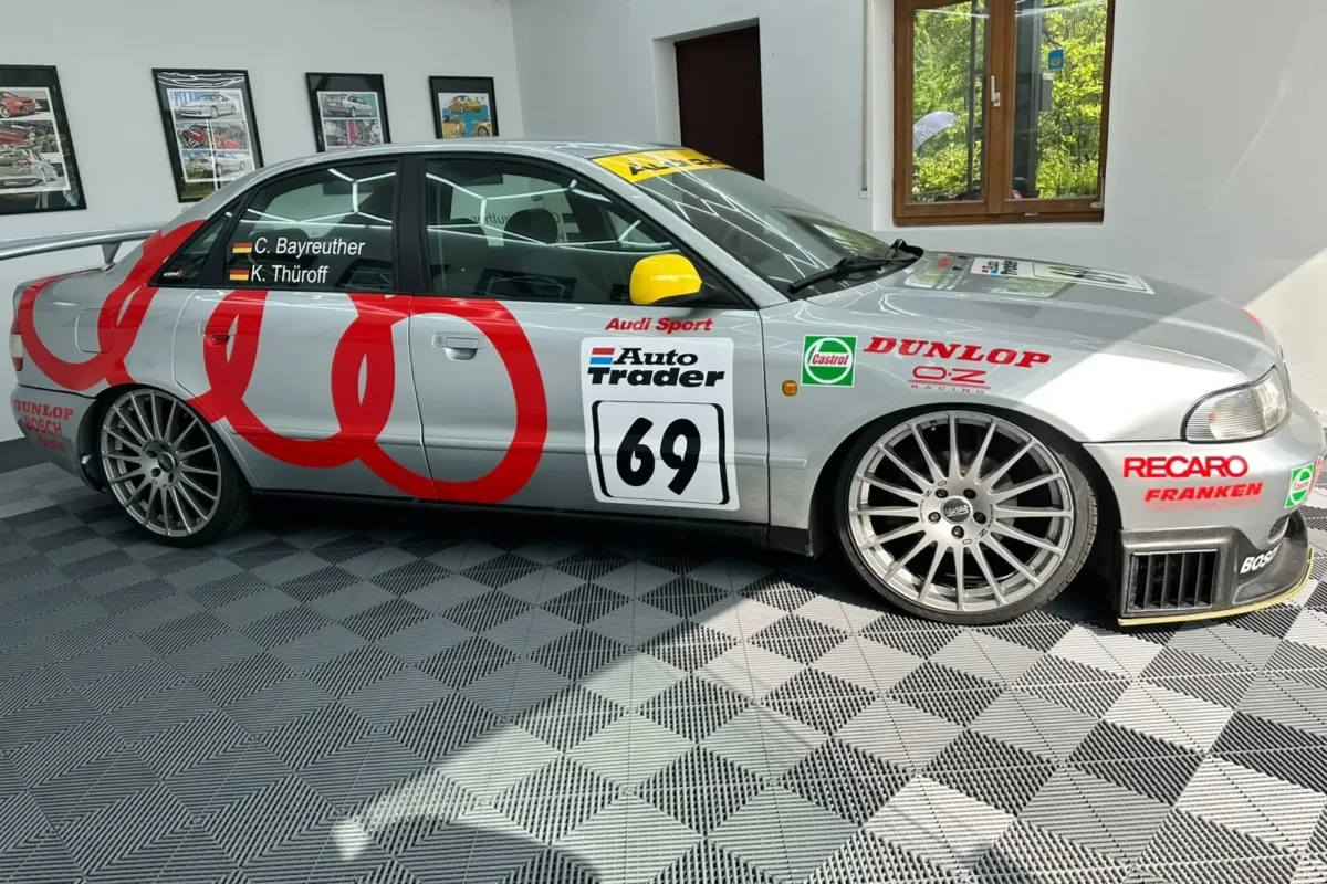 Audi A4 B5 STW mit Startnummer 69, Audi-Sport-, Dunlop- und Castrol-Aufklebern und silbernen OZ-Racing-Felgen, Seitenansicht in der Halle