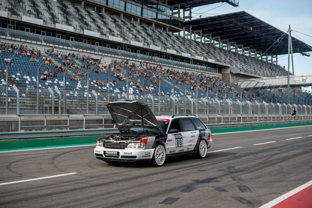 Audi S6 C4 20VT mit geöffneter Motorhaube in der Boxengasse vor der Tribüne