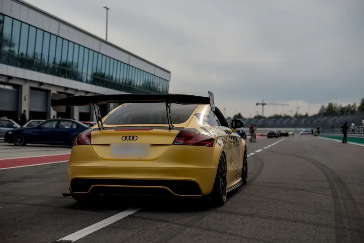 Gelber Audi TT RS 8J mit großem Heckflügel in der Boxengasse, Heckansicht