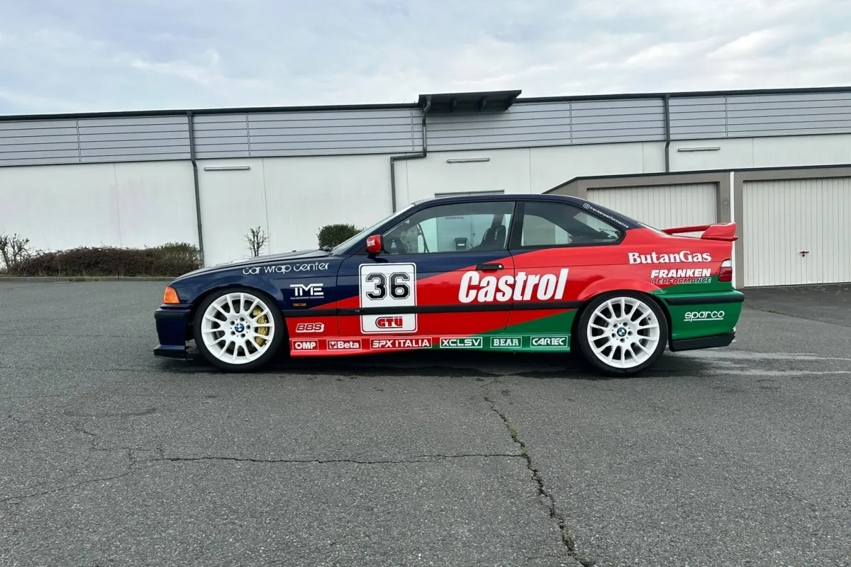 Seitenansicht des BMW E36 Coupé im Castrol-Design mit Startnummer 36, Sponsoren-Aufklebern, weißen Felgen und Heckflügel