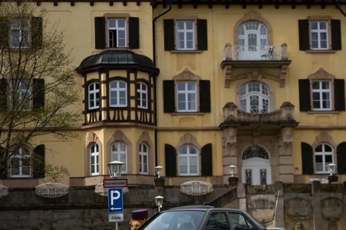 Mercedes-Benz 190 (W201) mit BBS-RS-Felgen, tiefergelegt vor der Fassade eines historischen Gebäudes mit Fachwerk-Obergeschoss, Erkern und Dachgauben