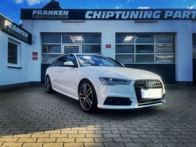 Weißer Audi A6 Avant (C7) mit großen Felgen vor der Werkstatt von Franken Performance