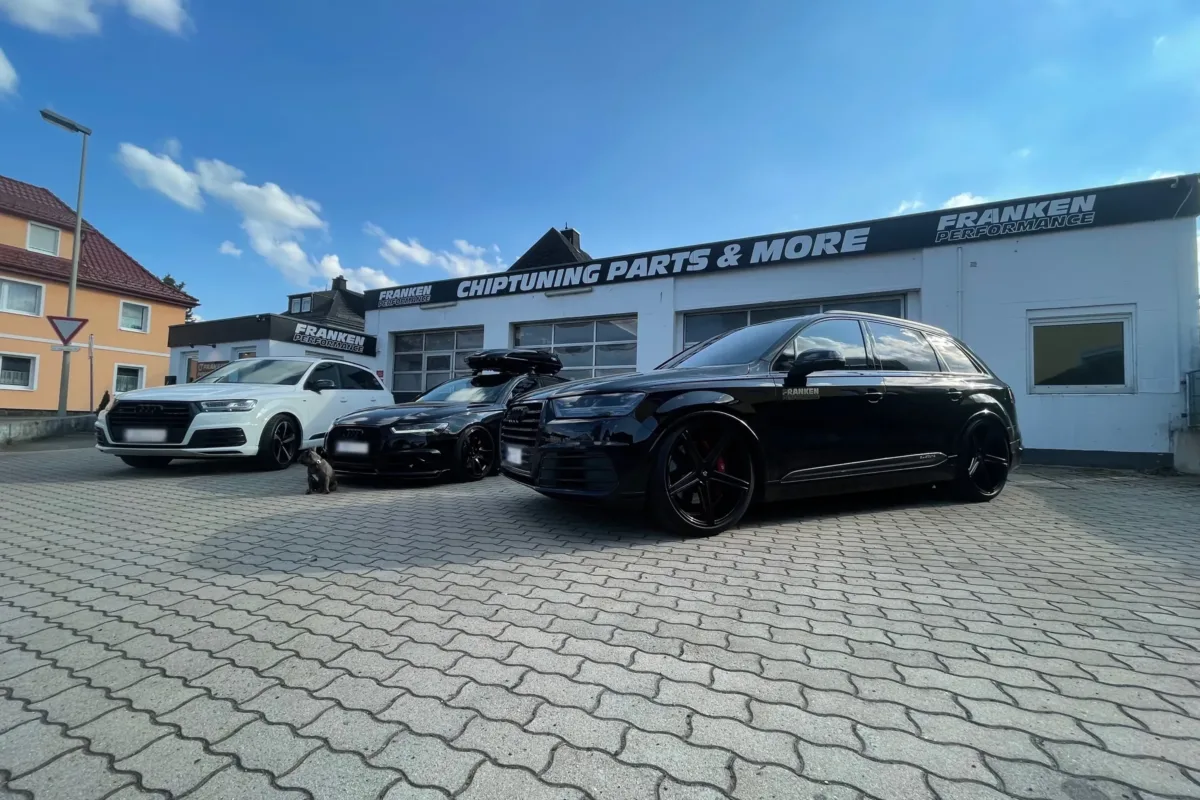 Schwarzer Audi SQ7 4M mit Franken-Performance-Schriftzug an der Tür, schwarzen MB-Design-Felgen und roten Bremssätteln vor der Werkstatt „Chiptuning Parts & More“, daneben weitere Audi-Modelle