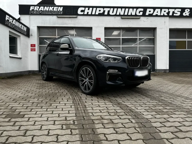 Schwarzer BMW X3 vor der Werkstatt von Franken Performance