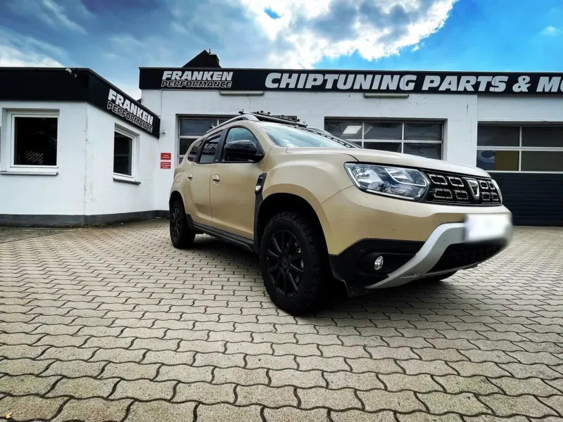 Sandfarbener Dacia Duster mit schwarzen Felgen vor der Werkstatt von Franken Performance