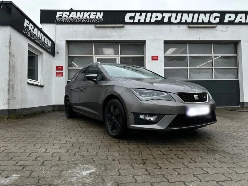 Grauer Seat Leon ST FR mit schwarzen Felgen vor der Werkstatt von Franken Performance