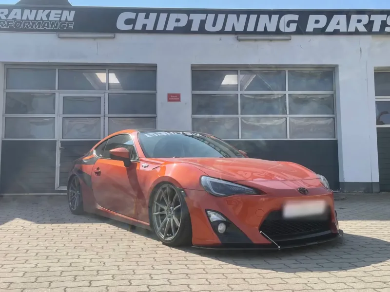 Orangefarbener Toyota GT86, tiefergelegt vor der Werkstatt von Franken Performance