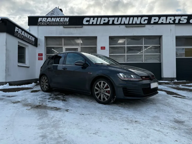 Dunkelgrauer VW Golf 7 GTI im Schnee vor der Werkstatt von Franken Performance