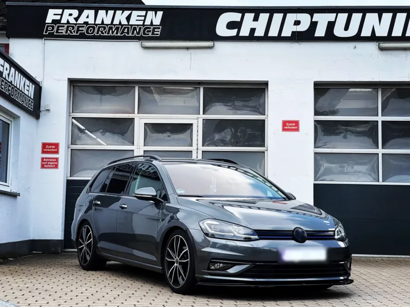 Grauer VW Golf 7 Variant mit Frontspoilerlippe vor der Werkstatt von Franken Performance